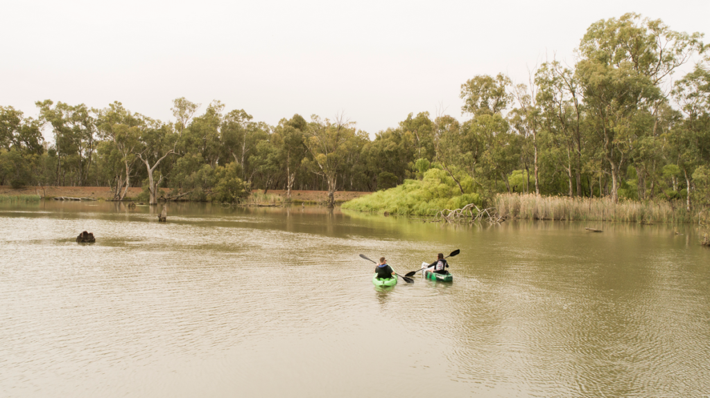 Image shows two people in canoes on the water at Rocky Waterholes, Narrandera